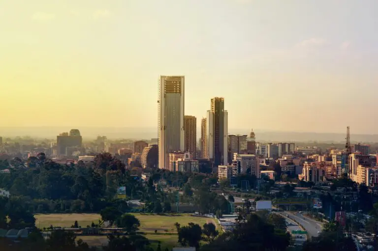 city skyline at sunset with modern skyscrapers and green spaces